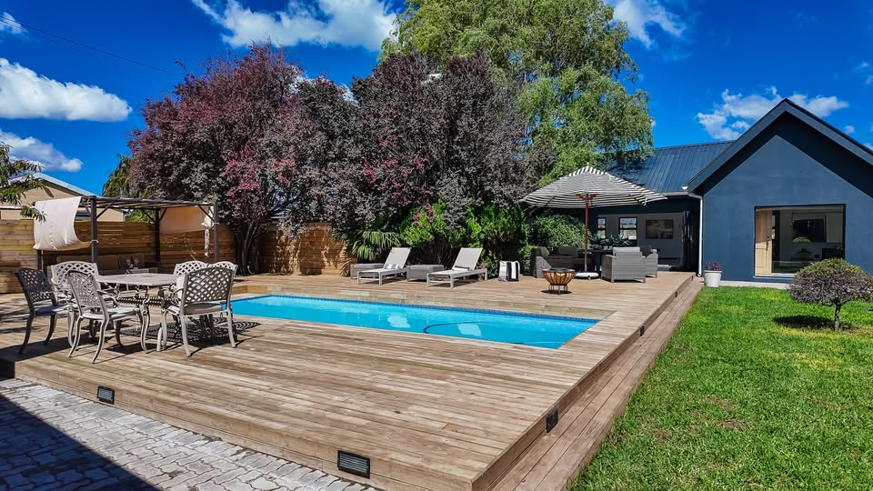 Outdoor pool and wooden deck surrounded by trees